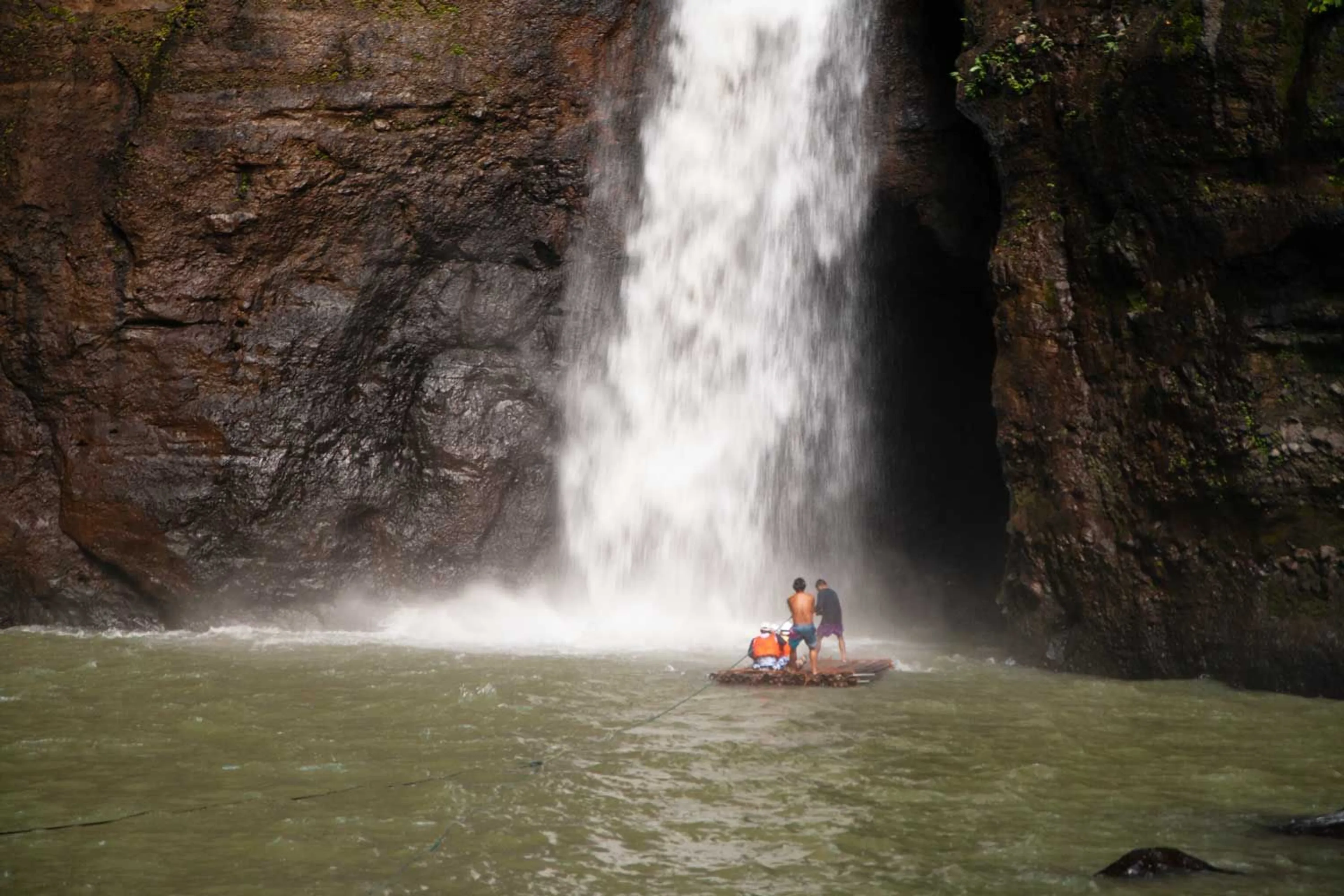 A balsa is navigating through Pagsanjan Falls